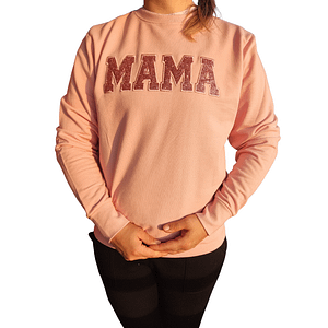 Ženski pulover, na katerem je v sredini vezen napis 'MAMA' obrobljen s bleščicami.